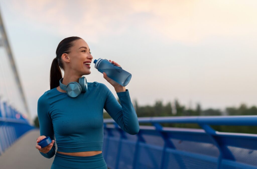 A person running and drinking water while wearing contact lenses